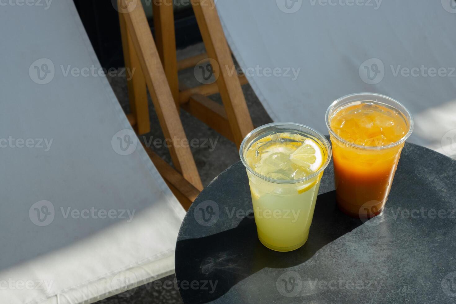 Takeaway glasses of summer drinks with ice. Lemonades and coctails on the table photo