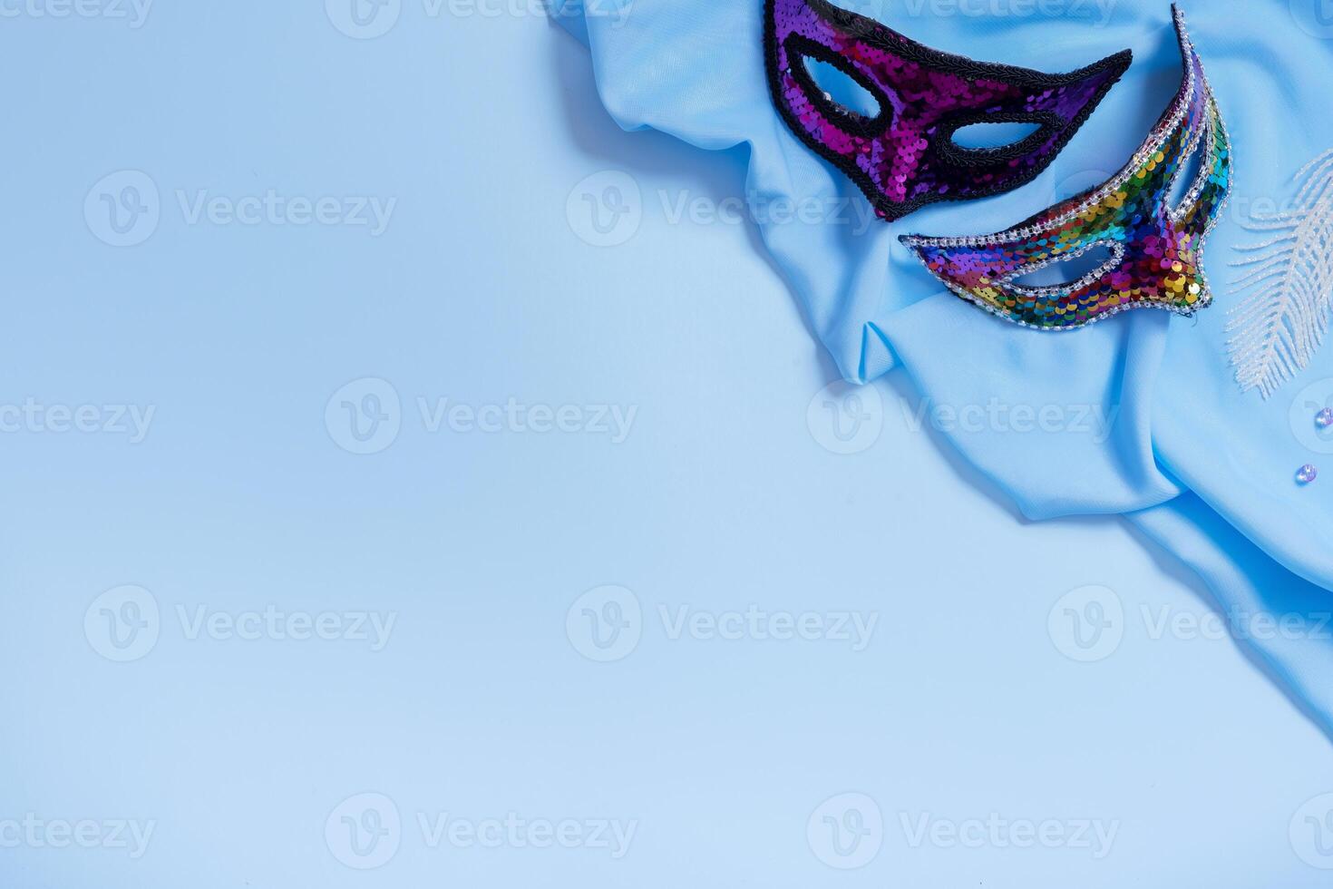 Face masks for carnival celebration on blue background with copy space photo