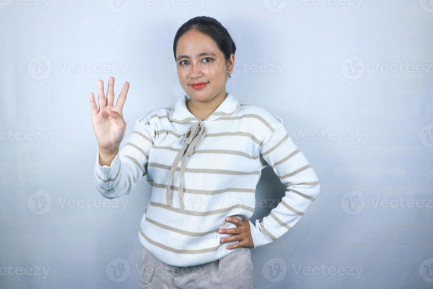 Beautiful asian young woman wearing sweater showing fingers number four while smiling confident photo
