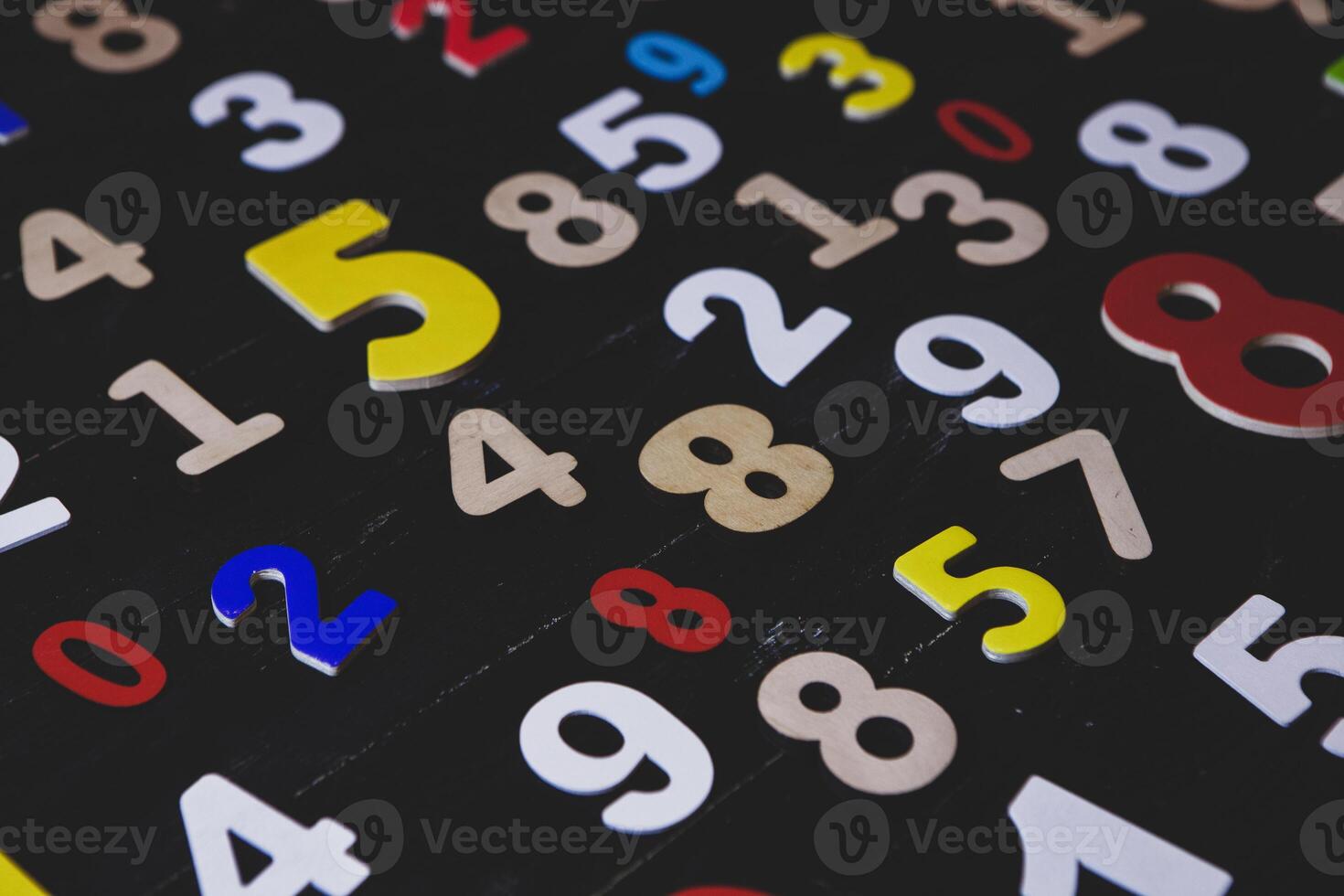 Colorful numbers on a black wooden table, close-up shot photo