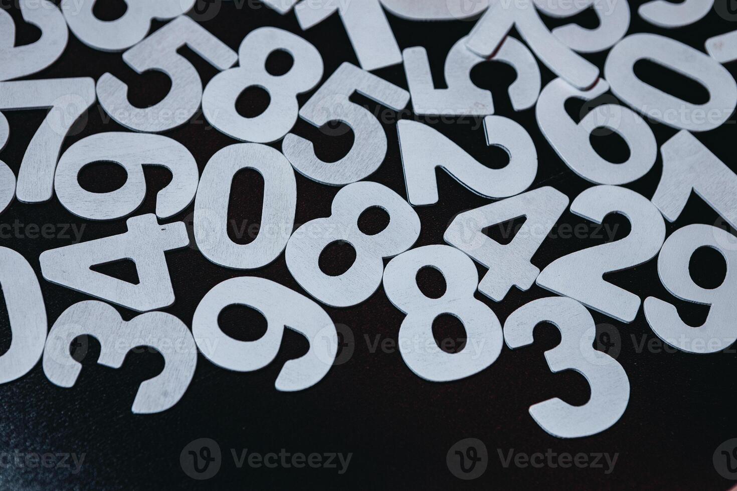 Numbers on black background. Numbers are scattered on the table. Black and white. photo