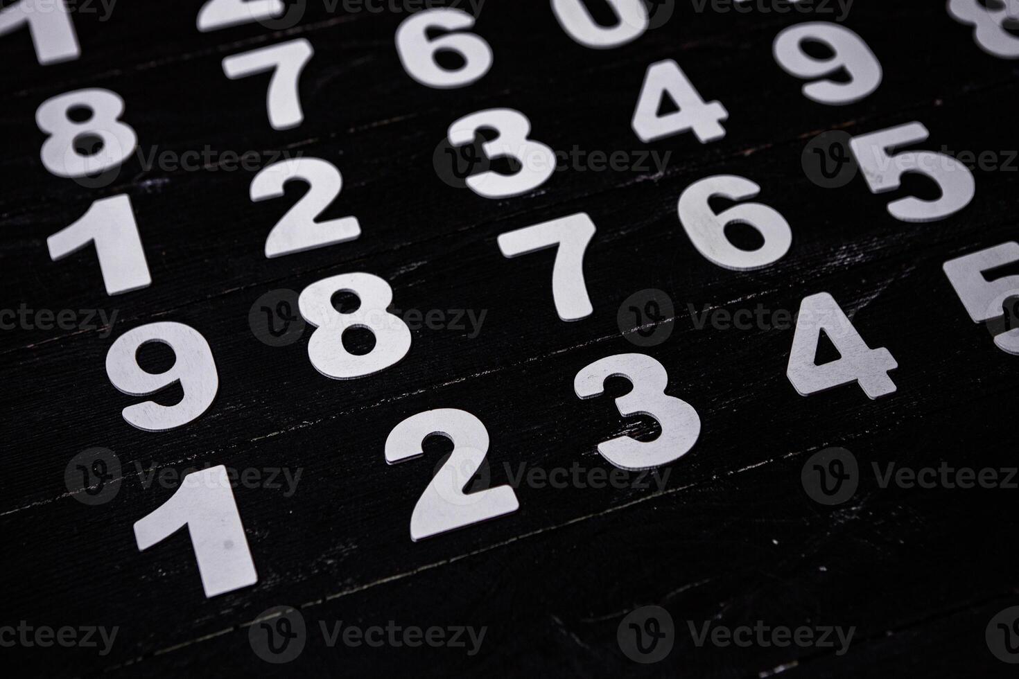 White numbers on a black background. Numbers scattered on the table. photo