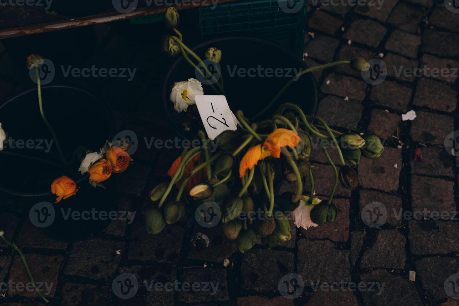 Wilted flowers on sale in a bucket at a market, offering a nostalgic, rustic charm photo
