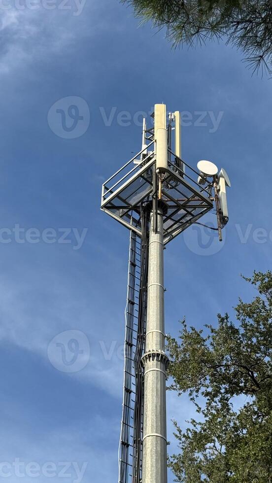 Cell tower with antennas against a blue sky. High quality photos