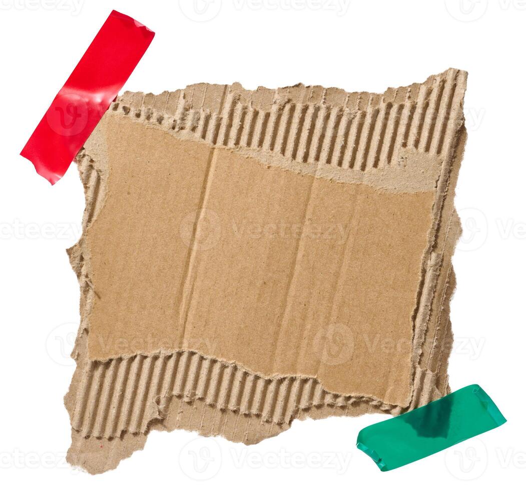 Torn piece of brown corrugated cardboard attached to a piece of electrical tape, isolated background photo