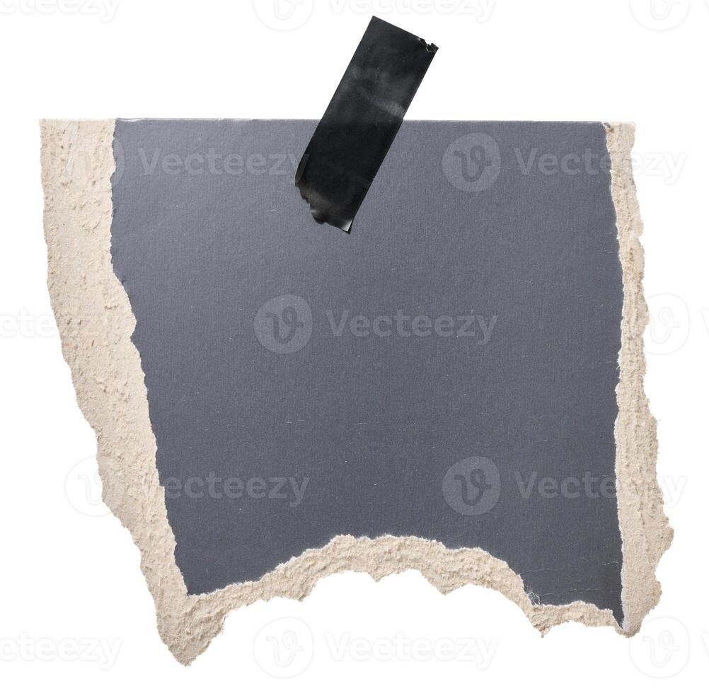 Torn piece of black cardboard attached to a piece of electrical tape, isolated background photo