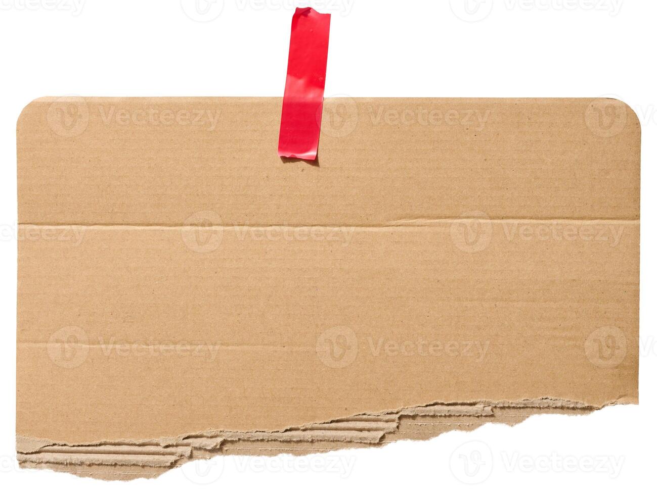 Torn piece of brown corrugated cardboard attached to red piece of electrical tape, isolated background photo