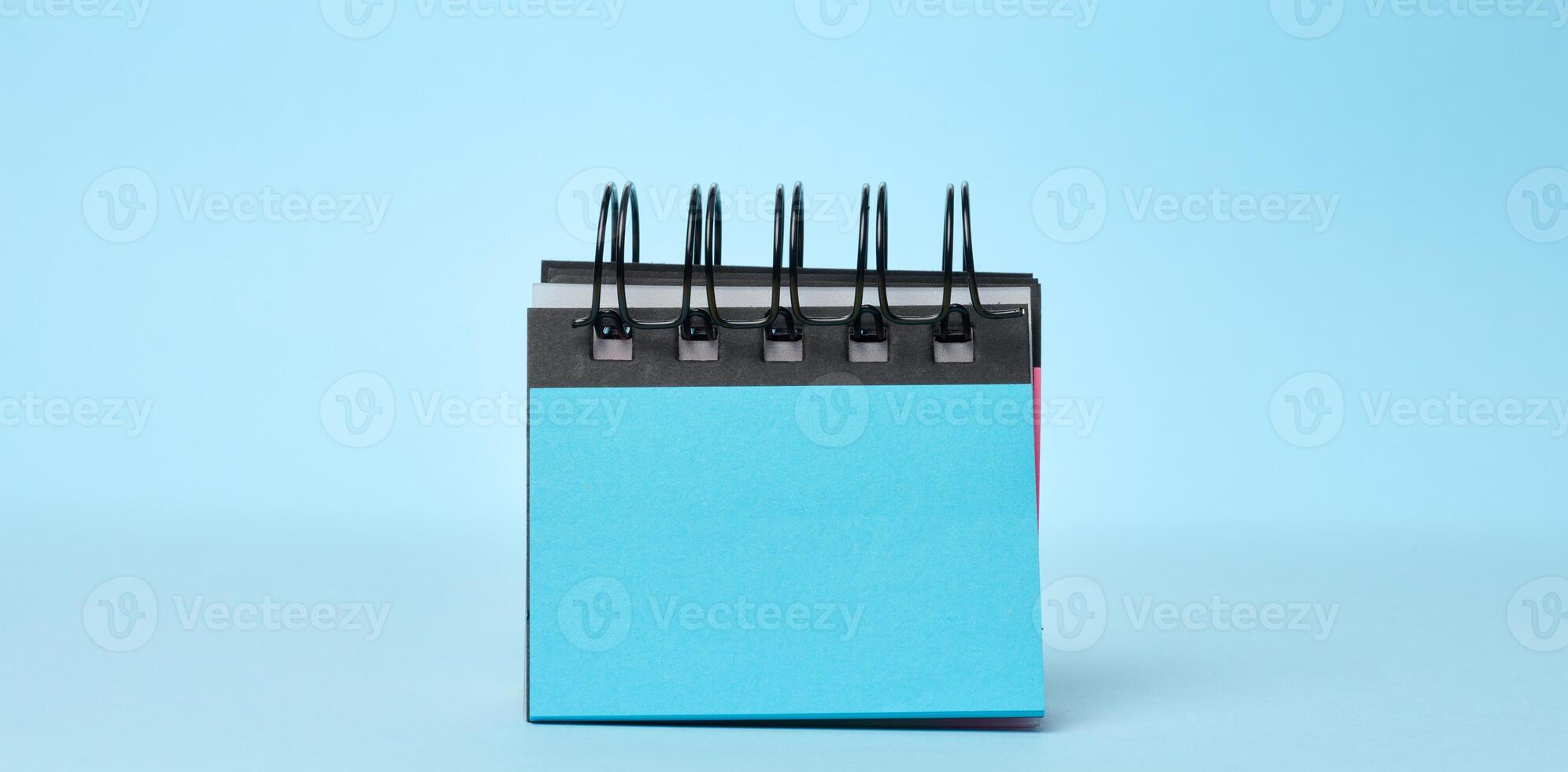 Notepad with empty blue sheets on a blue background photo