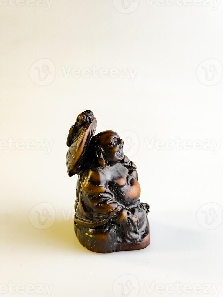 A figurine of a funny, laughing and cheerful golden copper Buddha or Hotei on a white background photo