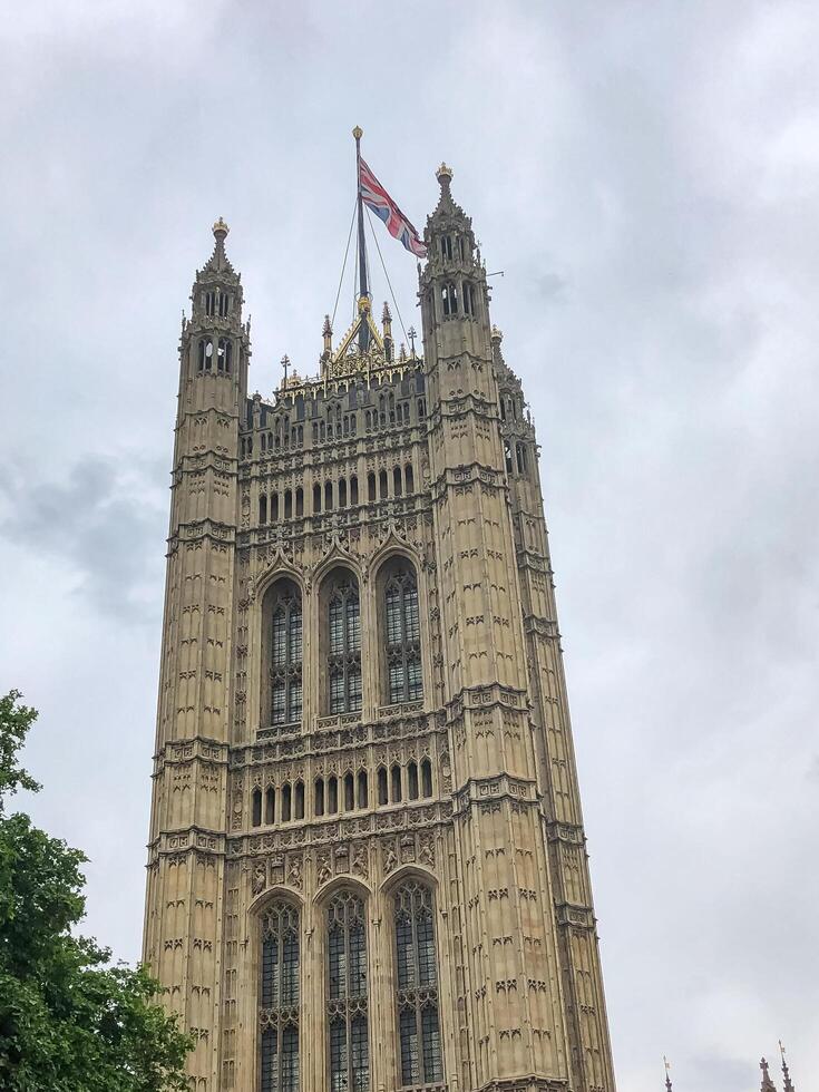 London, UK - 06.05.2019 View of the Victoria Tower with the UK flag in cloudy weather photo