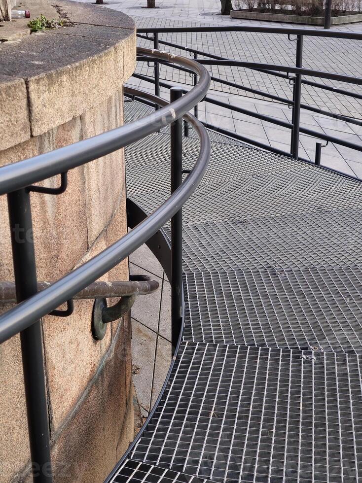 a metal railing is next to a stone wall photo