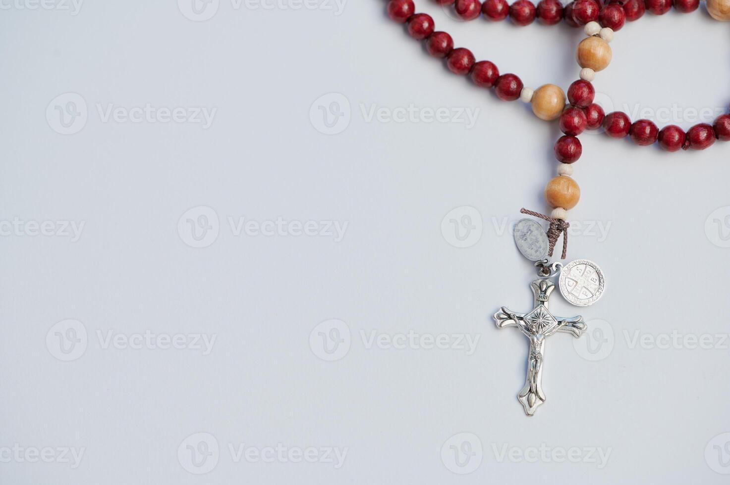 Rosary displayed for prayer with wooden beads against a simple white background photo