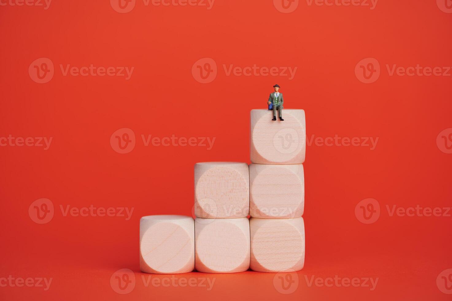 Miniature businessman climbs blocks symbolizing success and growth photo