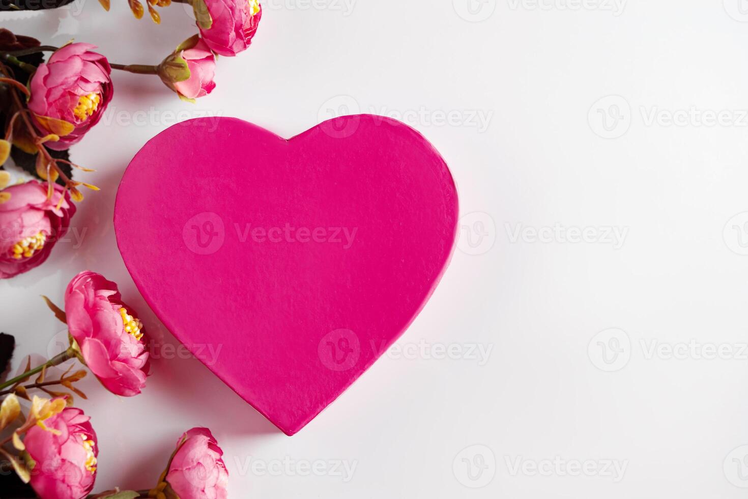 Pink heart for valentines day on background of flowers. Copy space photo