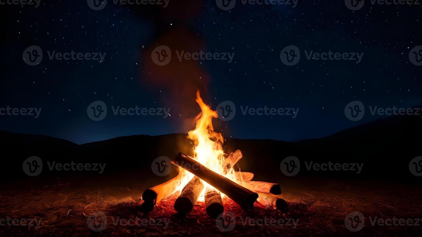 Glowing campfire flames dancing under the night sky, creating a cozy and warm atmosphere. photo