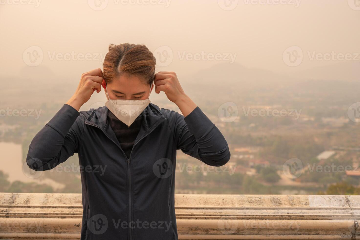 Asian woman wearing N95 mask for protect Bad air pollution PM2.5. PM2.5 levels meaning the air quality posed a health hazard. photo