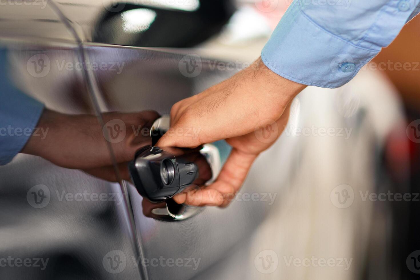 Cropped of man open car door, closeup of male hand with watch unlocking black auto door, making test drive at newest automobile showroom. Vehicle, transportation, car salon concept photo