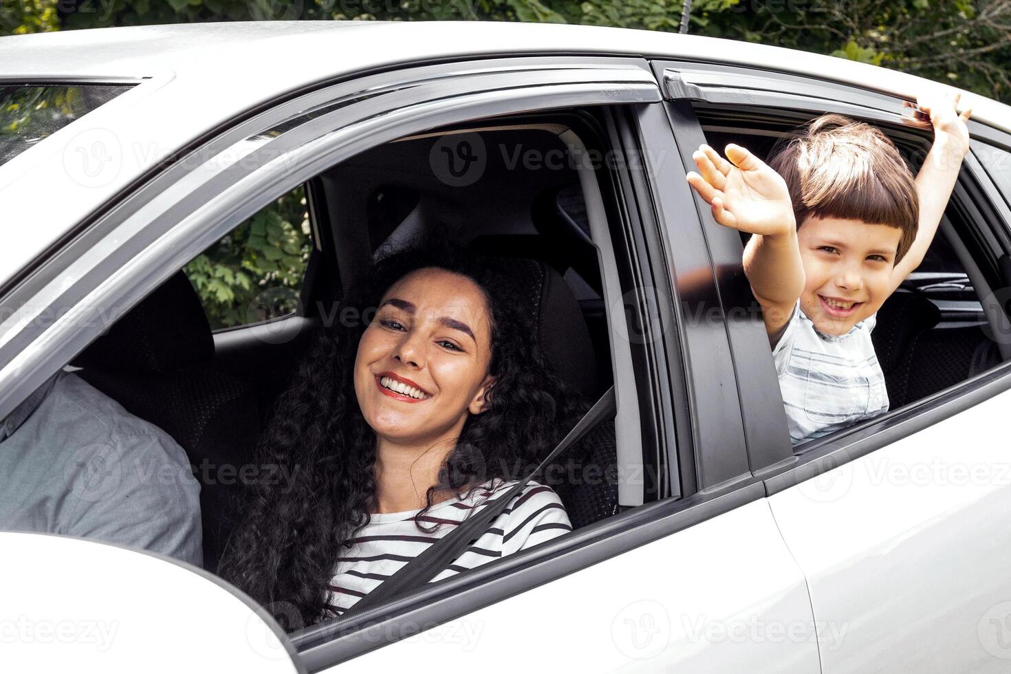 Happy cheerful millennial arab family with boy go to vacation by car at summer, kid waves his hand out the window, outdoor. Family trip on new auto, weekend together, love, relationship and lifestyle photo