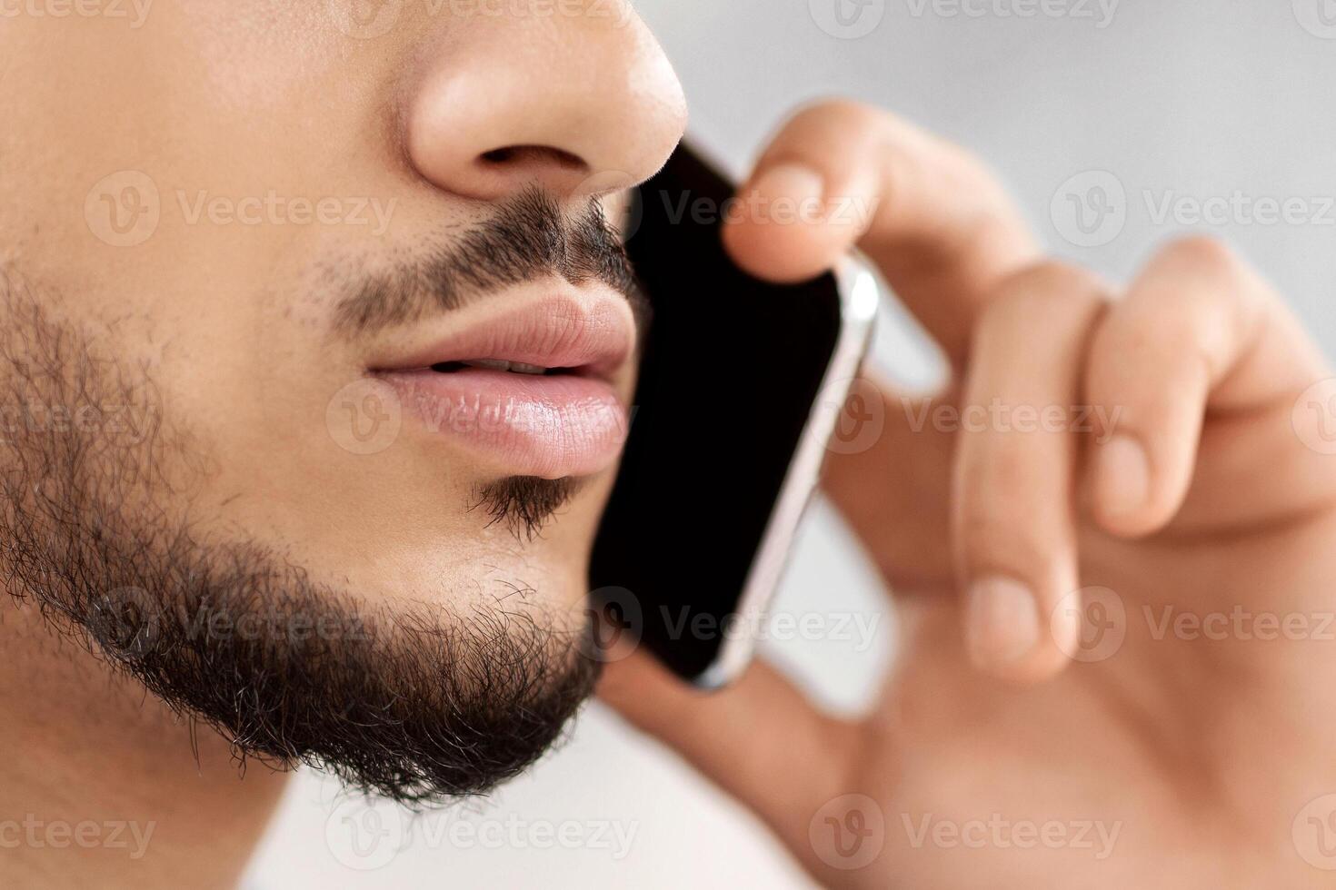 Business Call. Closeup Shot Of Young Serious Middle Eastern Man Talking On Cellphone, Unrecognizable Arab Businessman Having Mobile Conversation On Phone, Cropped Image With Selective Focus photo