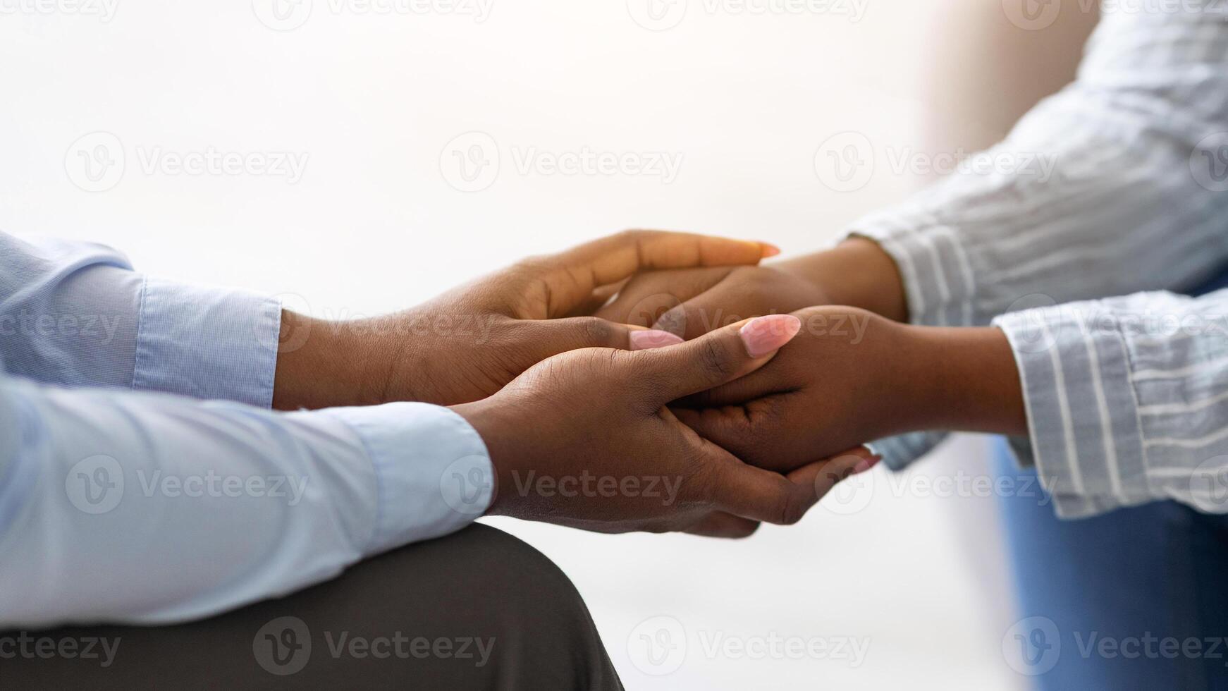 Psychological support. Psychotherapist offering help to young woman, holding her hands indoors, closeup view. Unrecognizable psychiatrist providing assistance to female patient photo