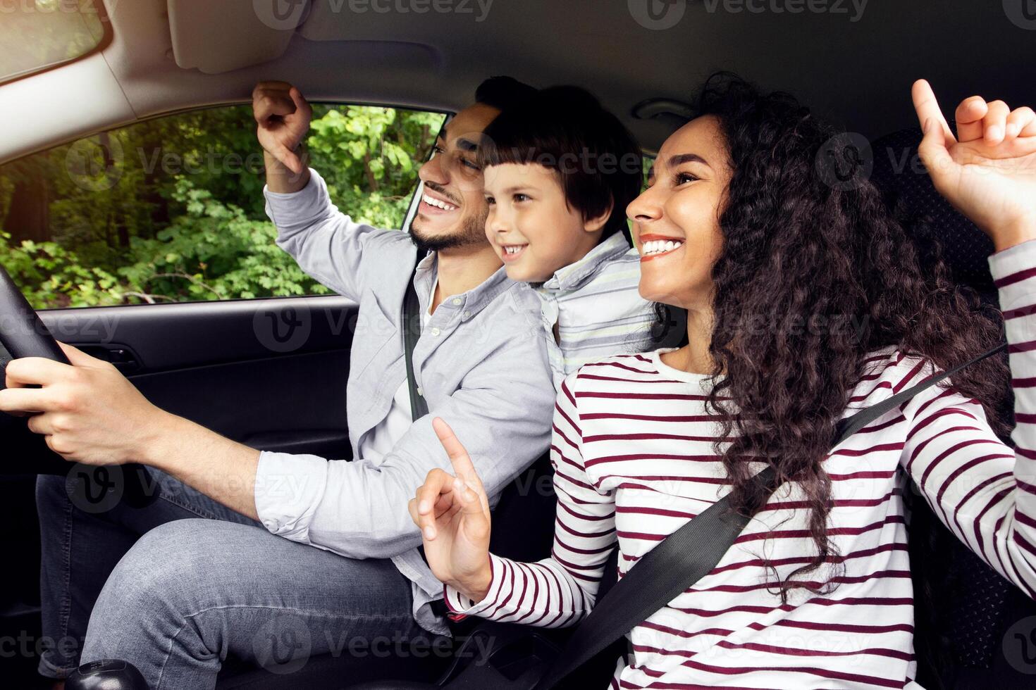 Happy middle eastern family mother father and little son travel by car together, cheerful arab parents and their child having fun while sitting inside of auto, enjoying automobile journey, closeup photo