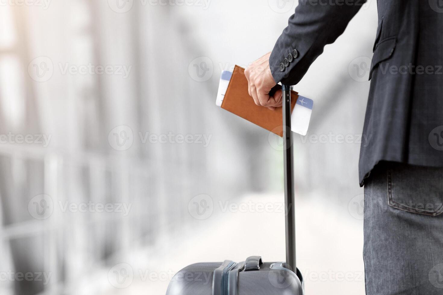 Air Travels Concept. Closeup Shot Of Man With Suitcase Holding Passport And Airline Tickets, Unrecognizable Male Traveller Waiting For Flight Boarding In Arport Terminal, Rear View, Cropped Image photo