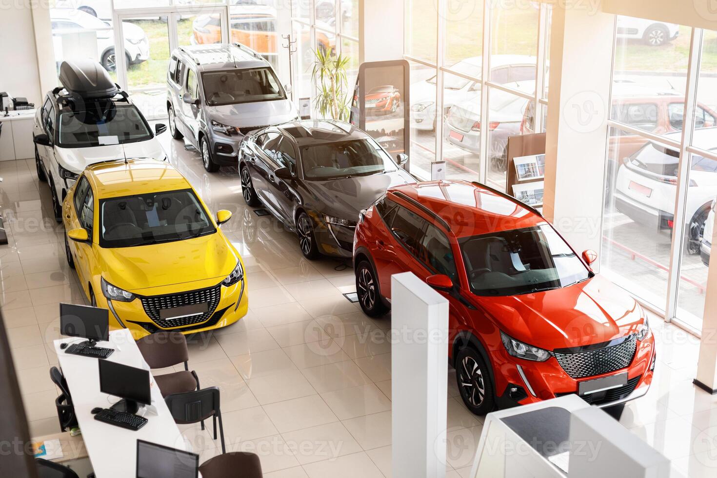 Top view of various beautiful modern sports, family, medium, multi purpose cars different colours and features at huge luxury dealership salon. Automobiles for sale, auto showroom, copy space photo