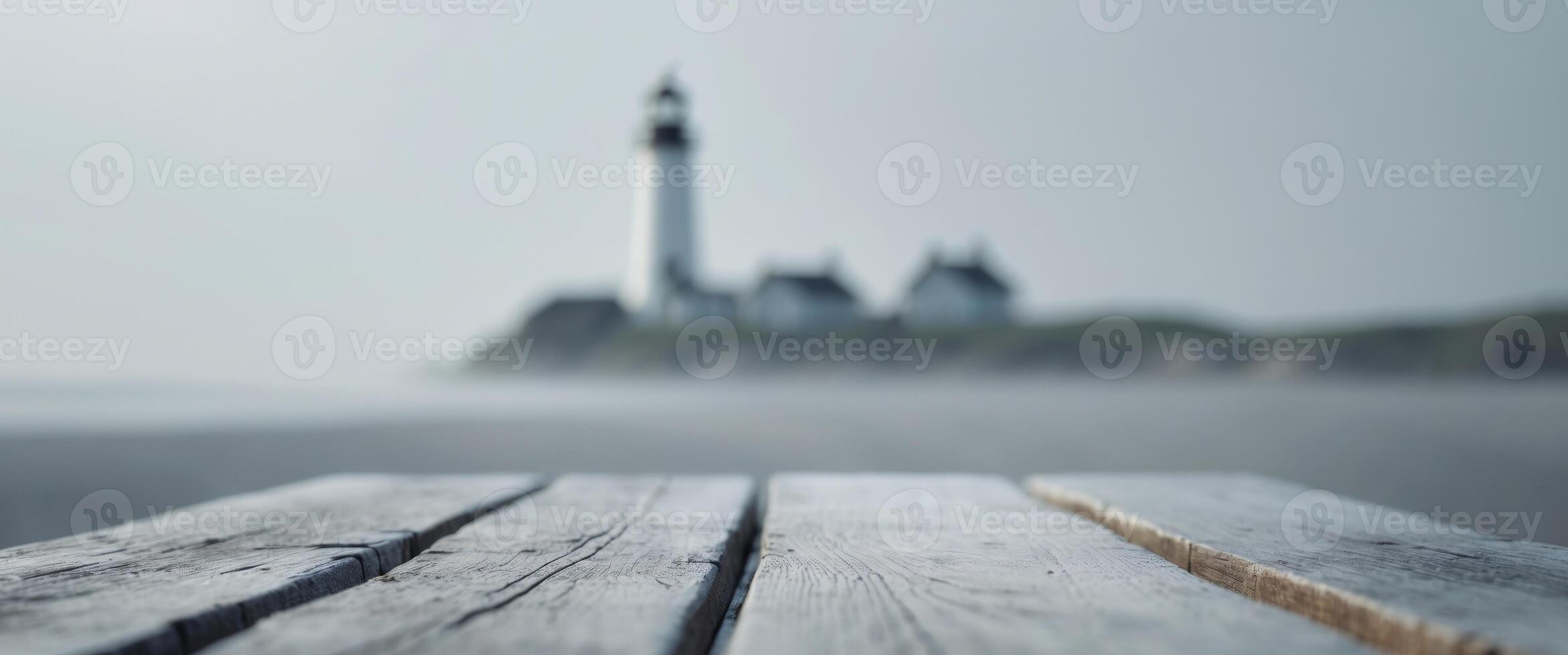 close up of empty wooden table with blurred lighthouse on shore background photo