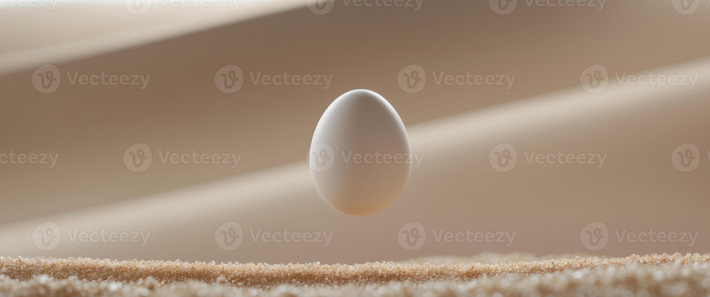 A close up of an egg falling into the sand photo