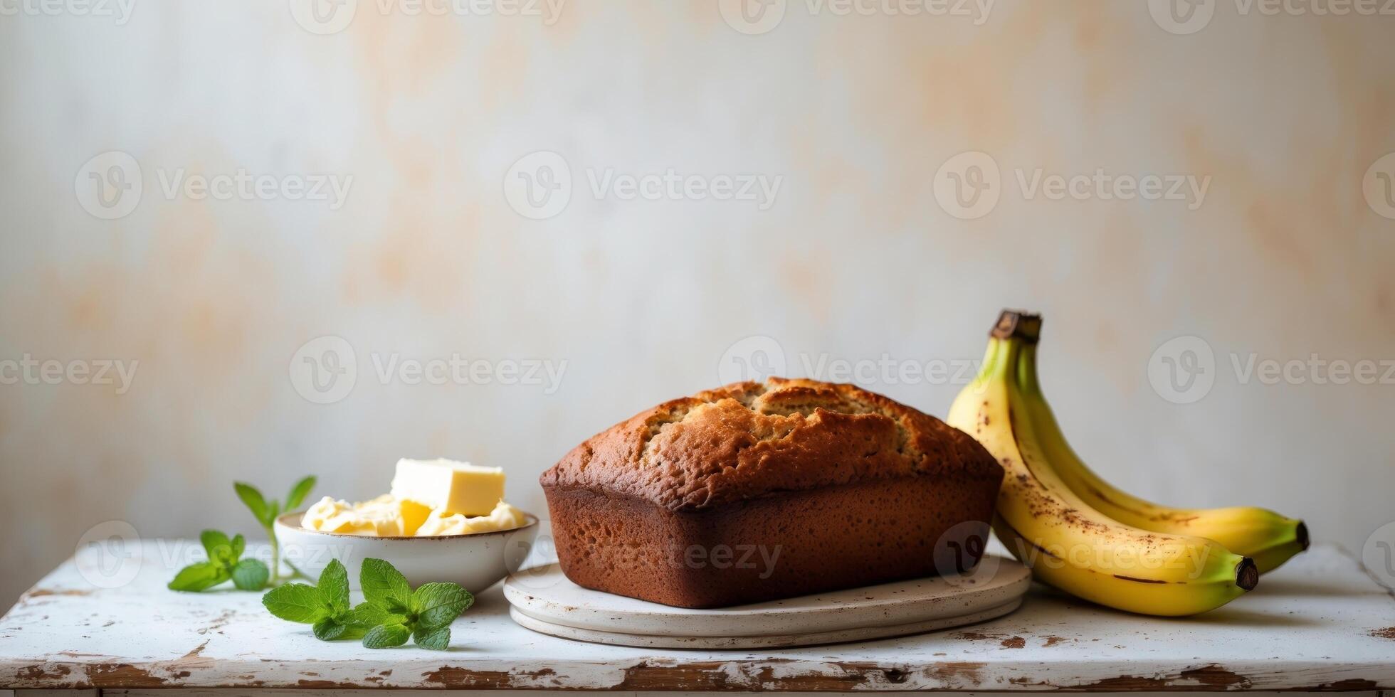 Golden loaf of banana bread surrounded by ingredients on a rustic table setting photo