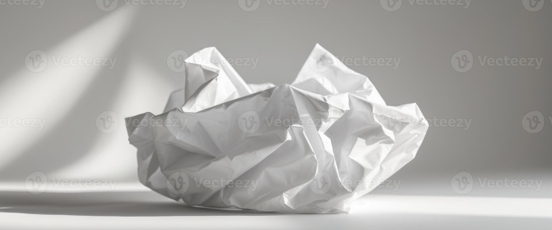 Crumpled white paper creates abstract shapes with light and shadow. photo