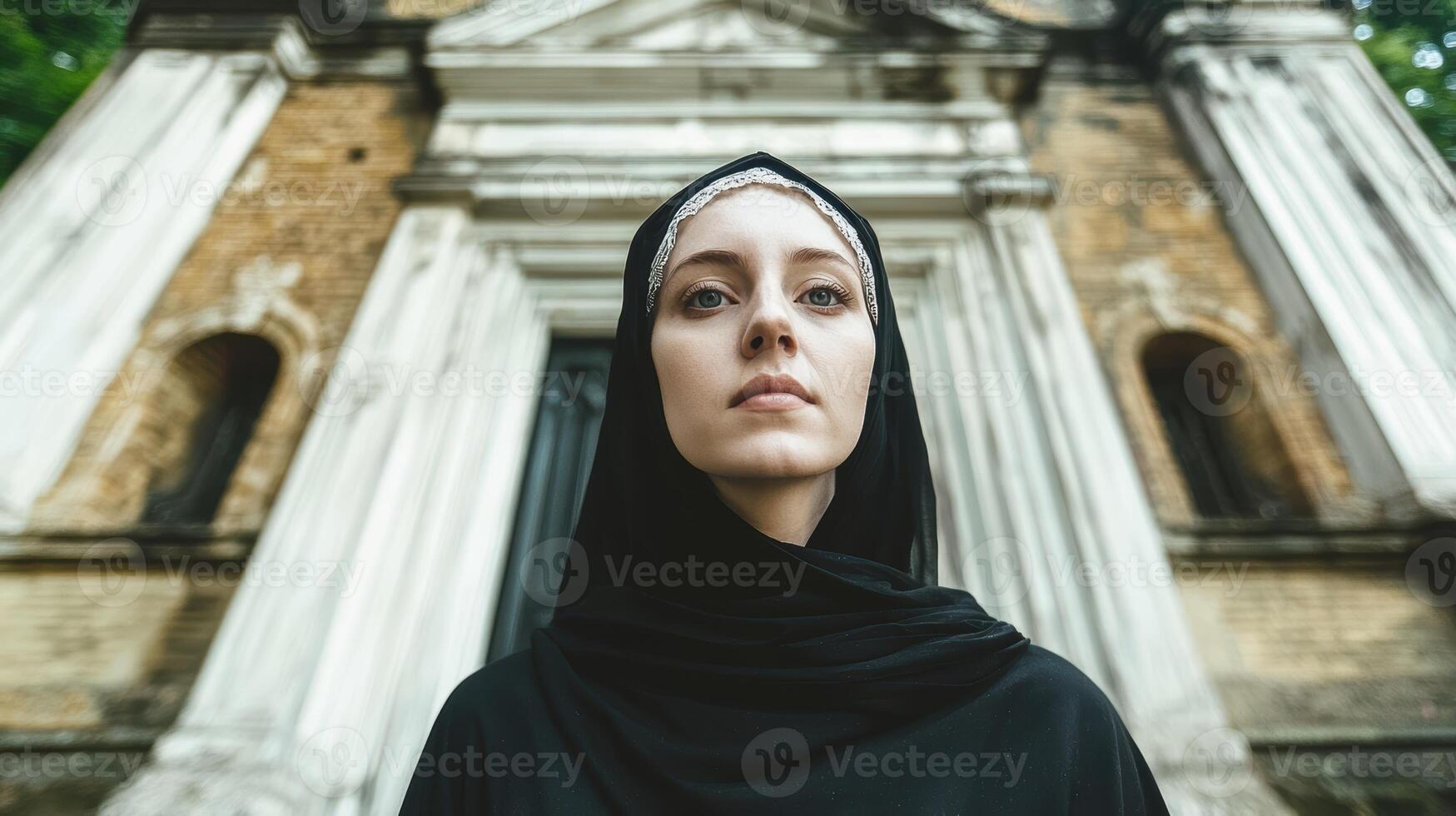Woman in black hijab standing in front of old building photo