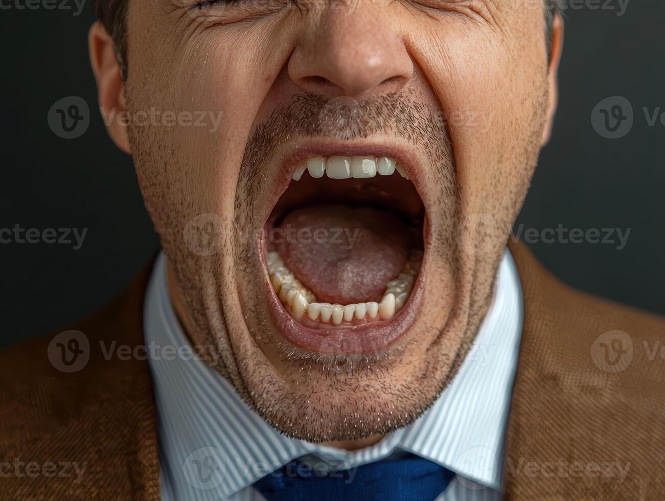 Close up of a man screaming with his mouth wide open photo