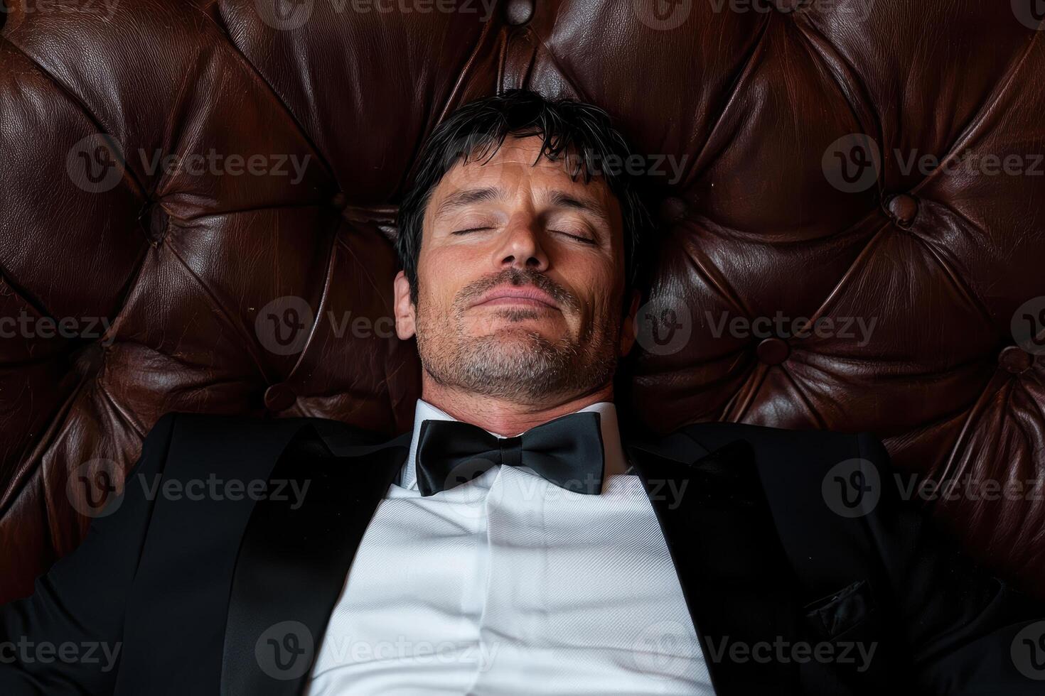 Elegant man relaxing on a luxurious leather couch photo