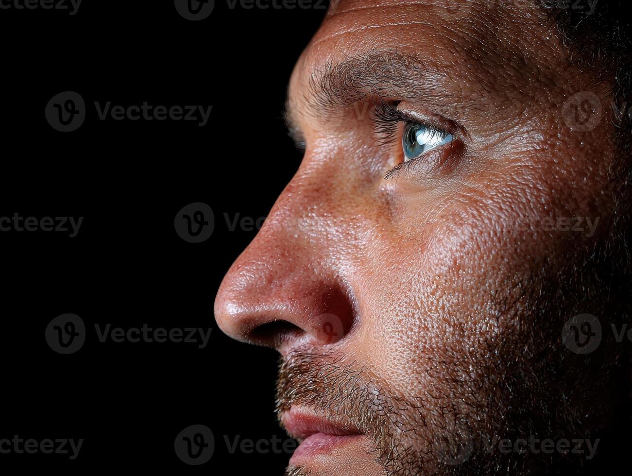 Close up profile of a mans face, showing his eye and stubble photo