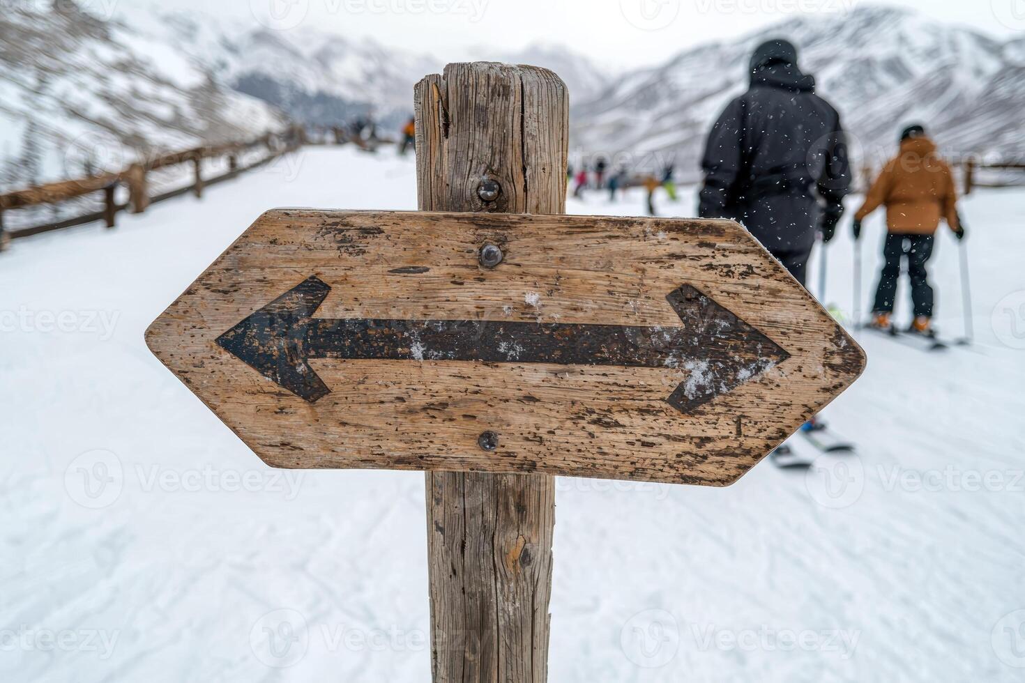 Wooden signpost with arrows pointing in opposite directions on a snowy mountain slope photo
