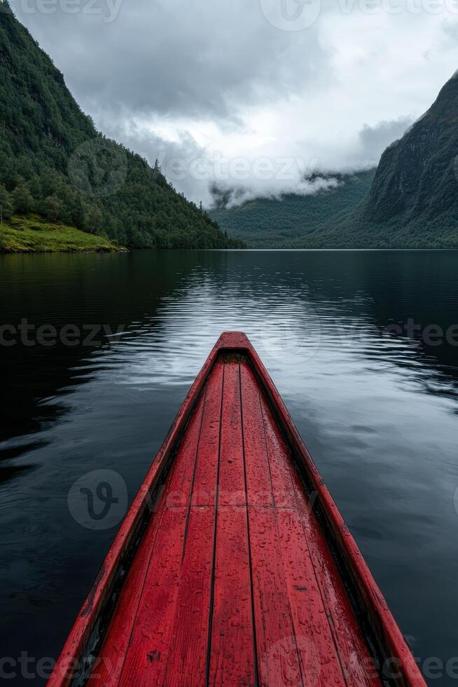 Red canoe on a calm lake surrounded by mountains photo