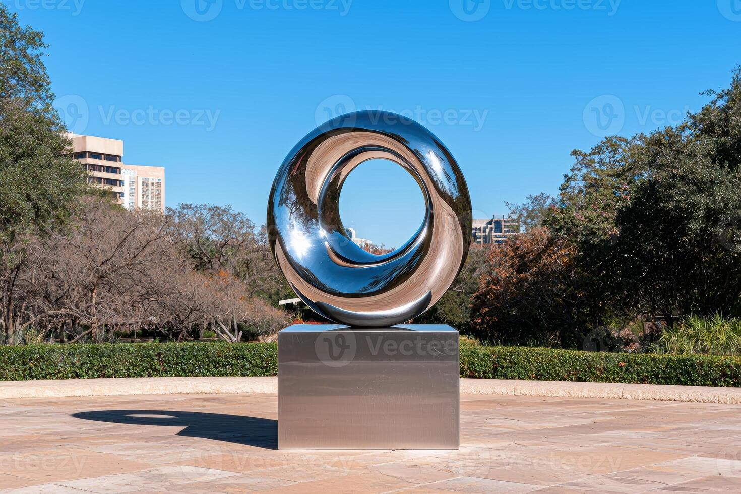 Modern polished metal sculpture in a garden setting photo