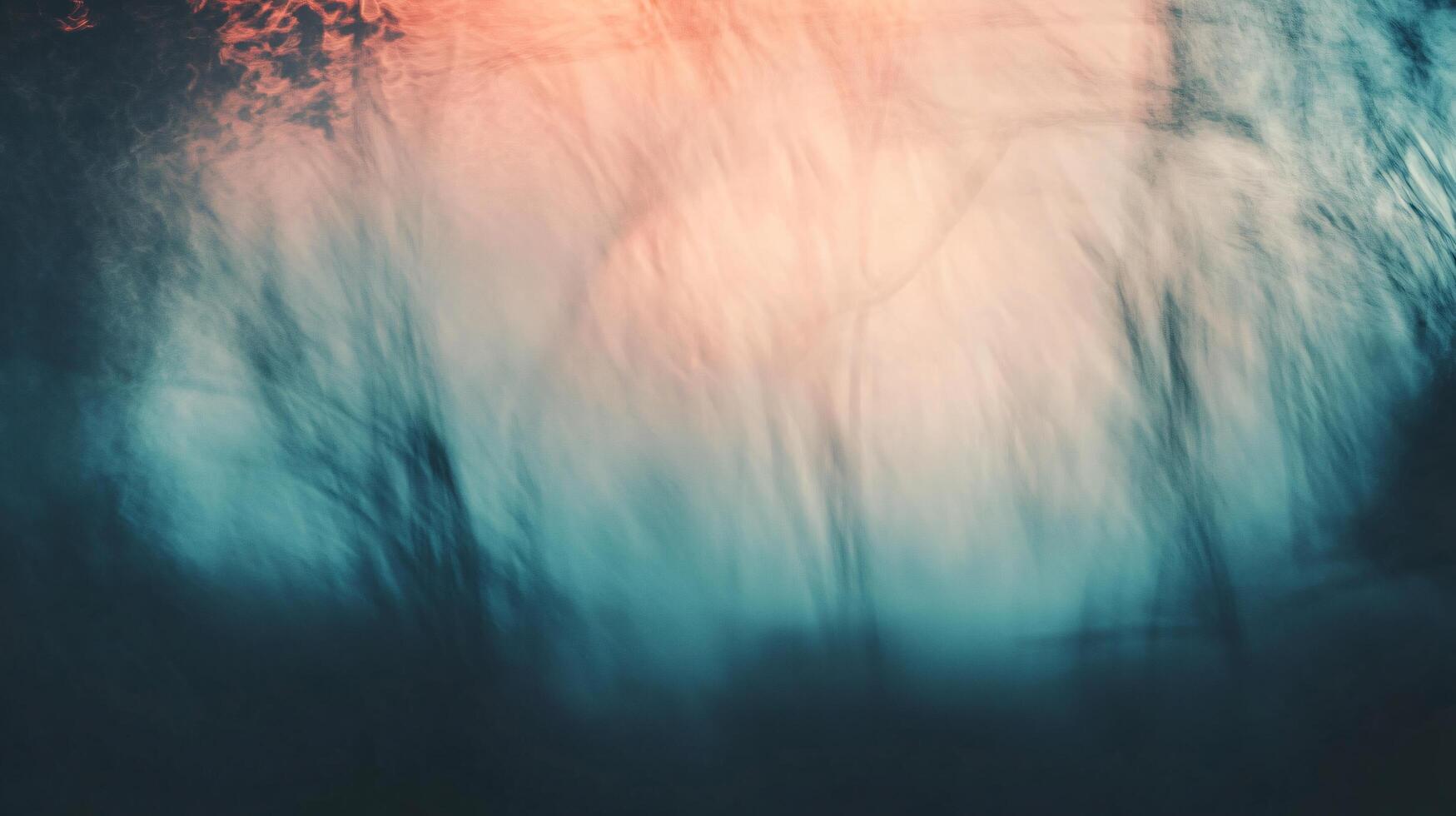 A blurry image of a forest with a blue sky in the background photo