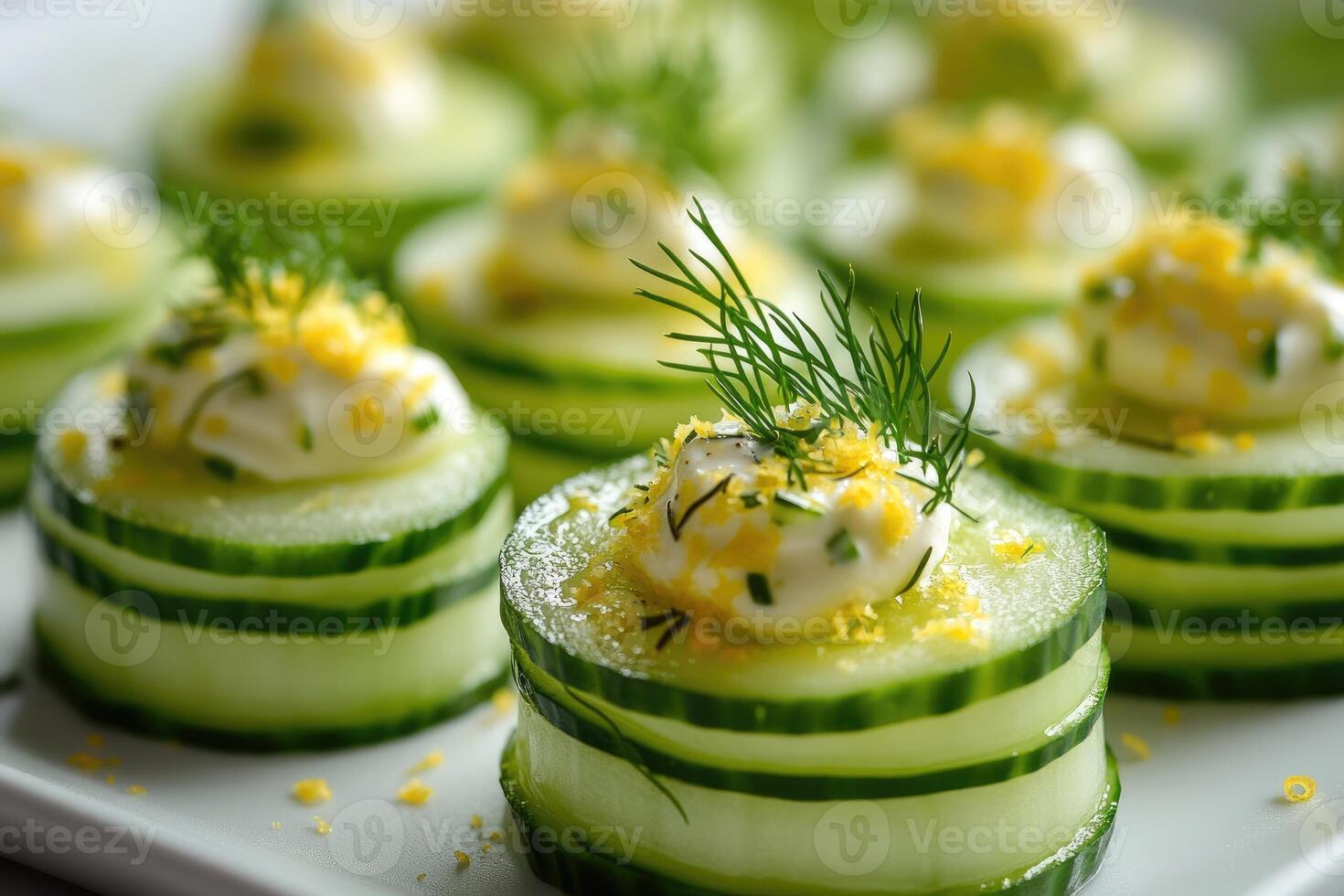 Cucumber appetizer bites with dill, yogurt and lemon zest on slate plate photo