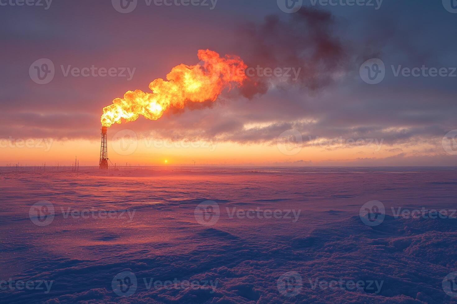 Gas flaring from industrial chimney at sunset in snowy landscape photo