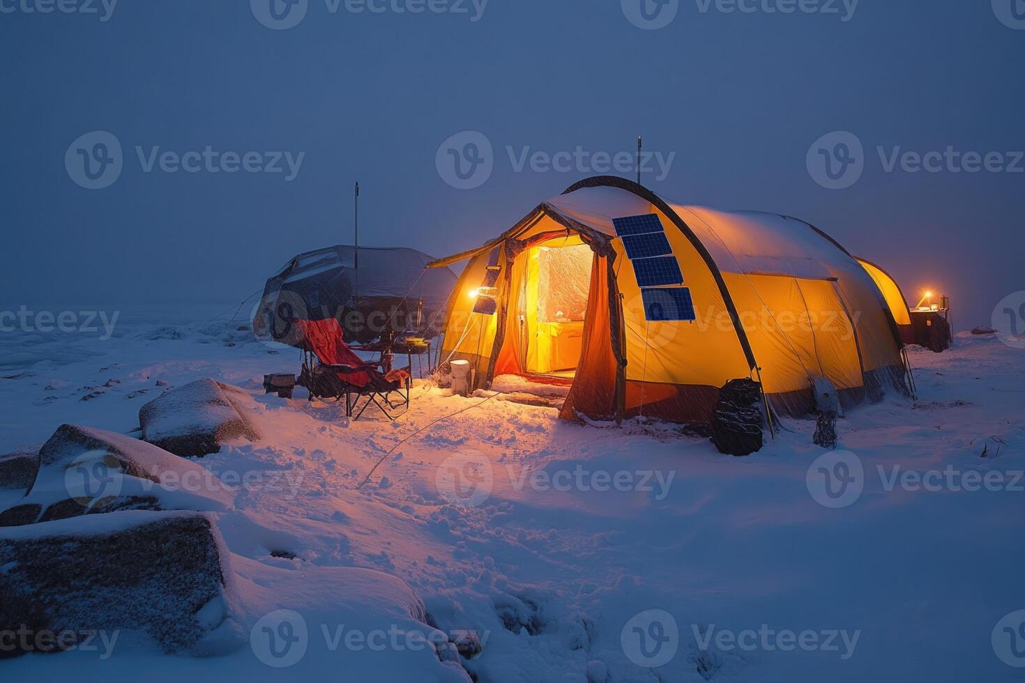Cozy winter camping with illuminated tent in snow photo