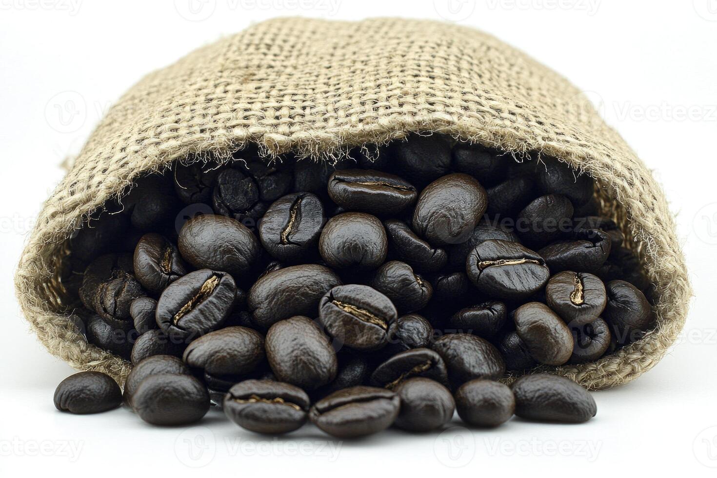 Burlap sack overflowing with dark coffee beans photo