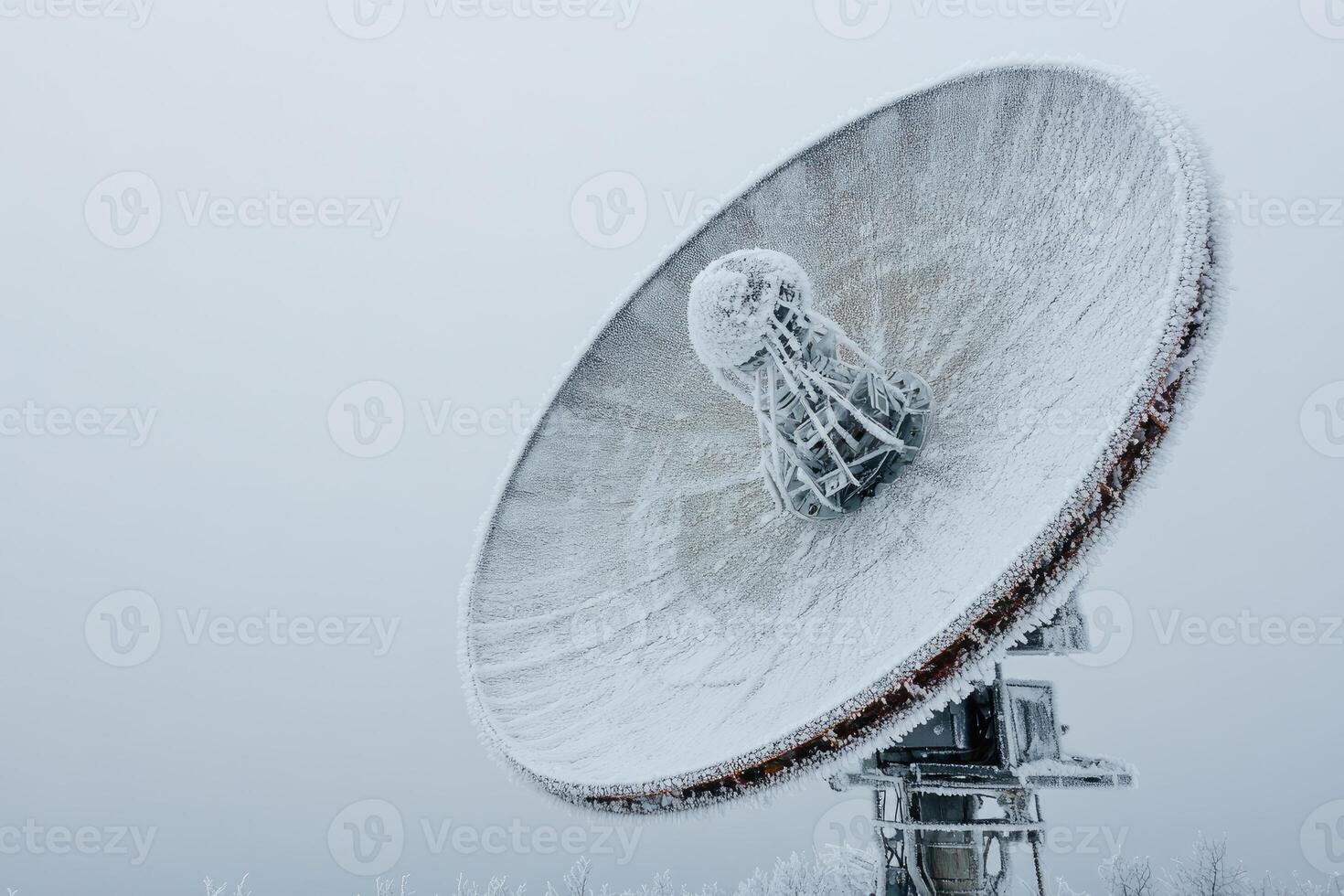 Large satellite dish covered with frost during winter. photo