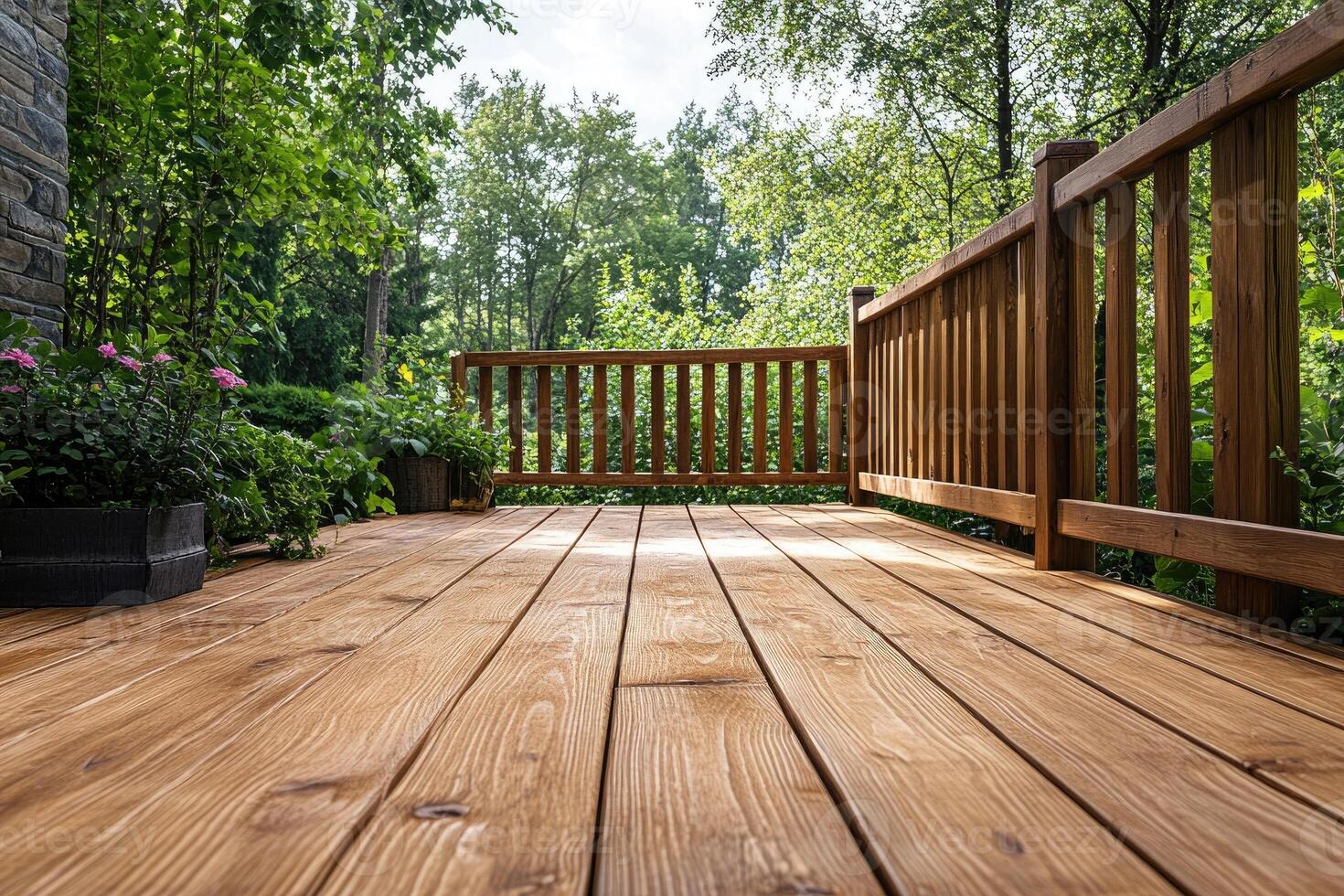 Wooden terrace overlooking lush green garden with railing in summer photo
