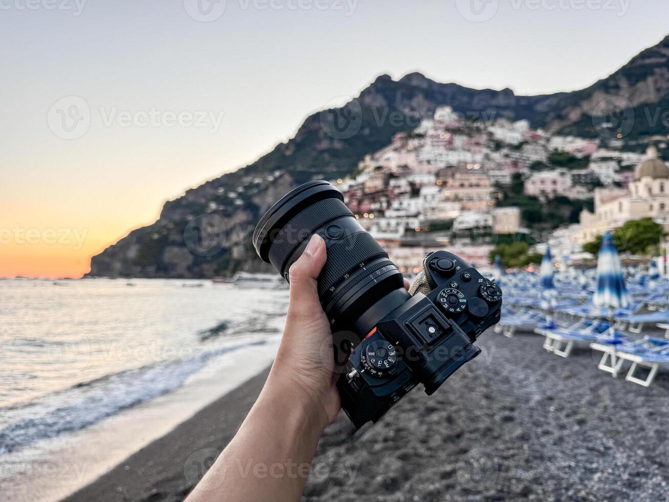 Camera in hand with view over Positano town and beach in Amalfi coast in Italy. photo