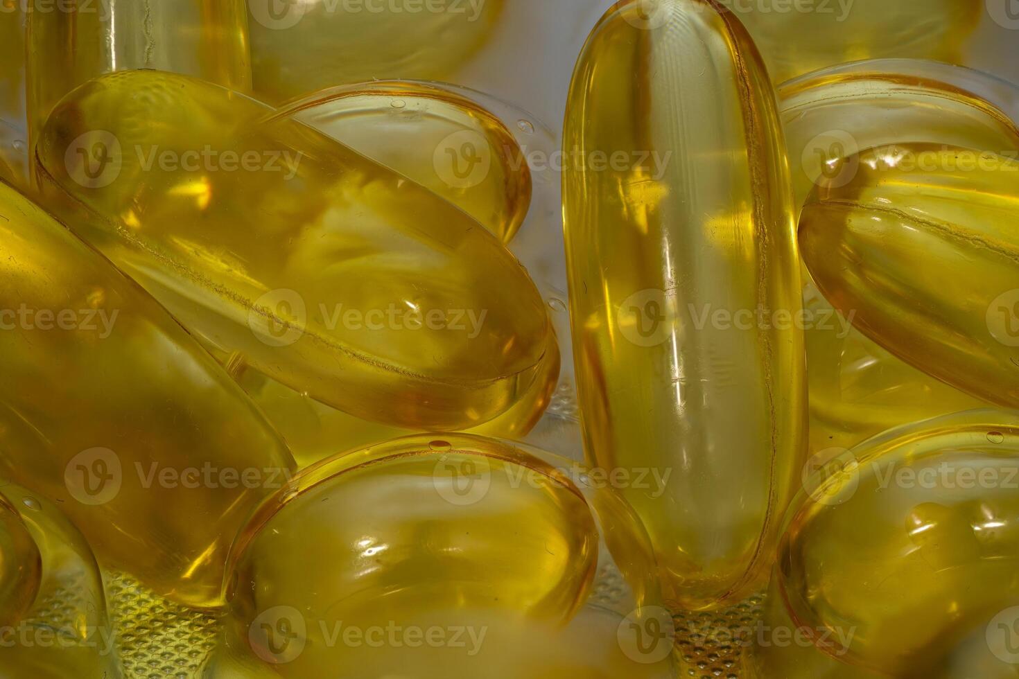 Bright yellow gel capsules for dietary supplements on a white background photo