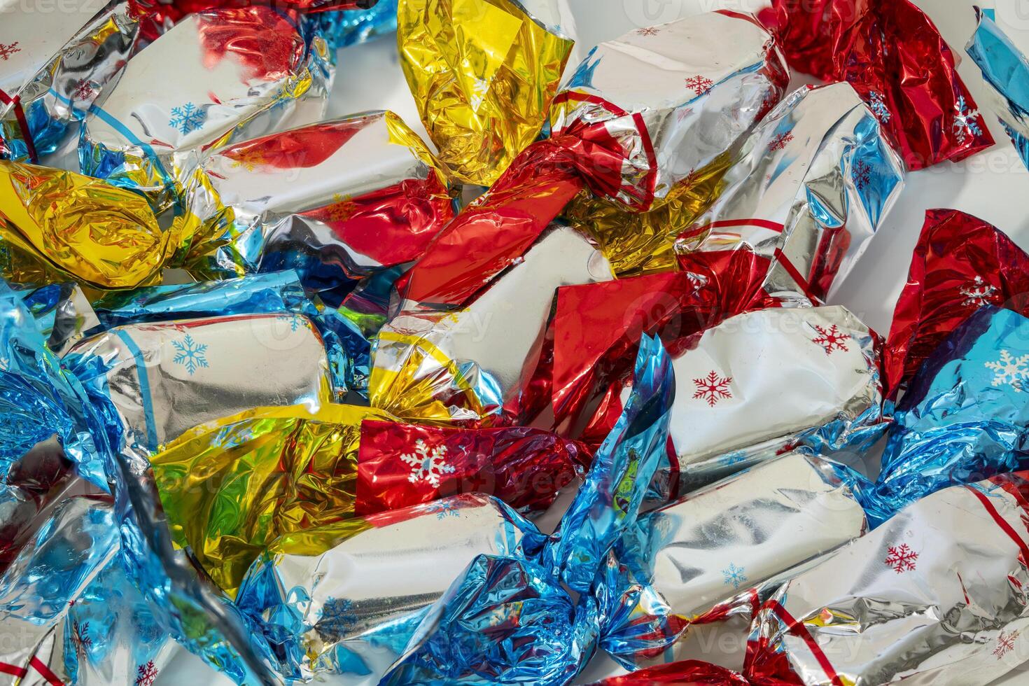 Colorful wrapped candies scattered on a white background in festive display photo