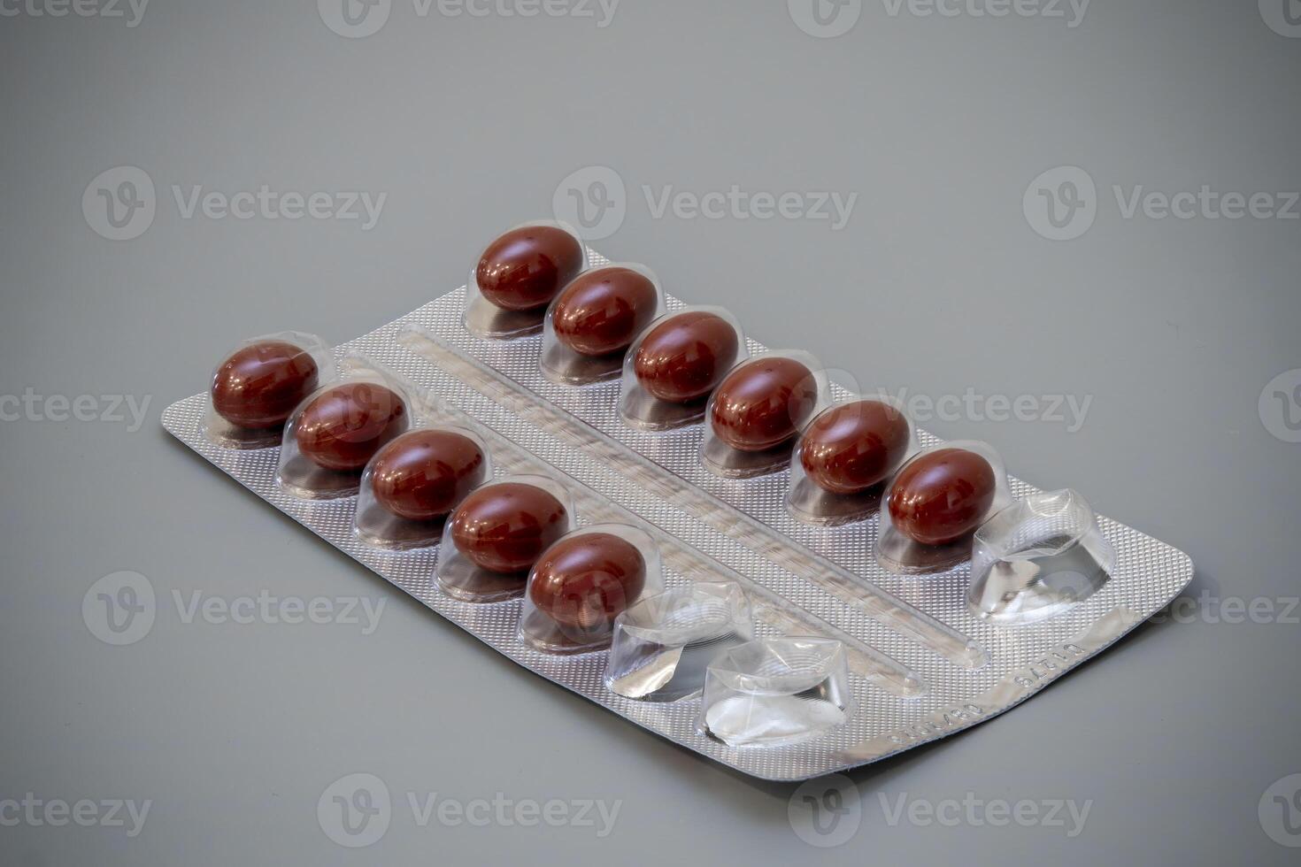 Bottles of brown capsules in a blister pack on a gray background photo