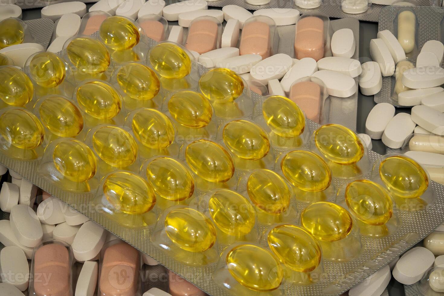 Various types of pills and capsules displayed on a surface photo